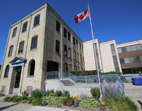 A three-storey building with a Canada flag flying in front