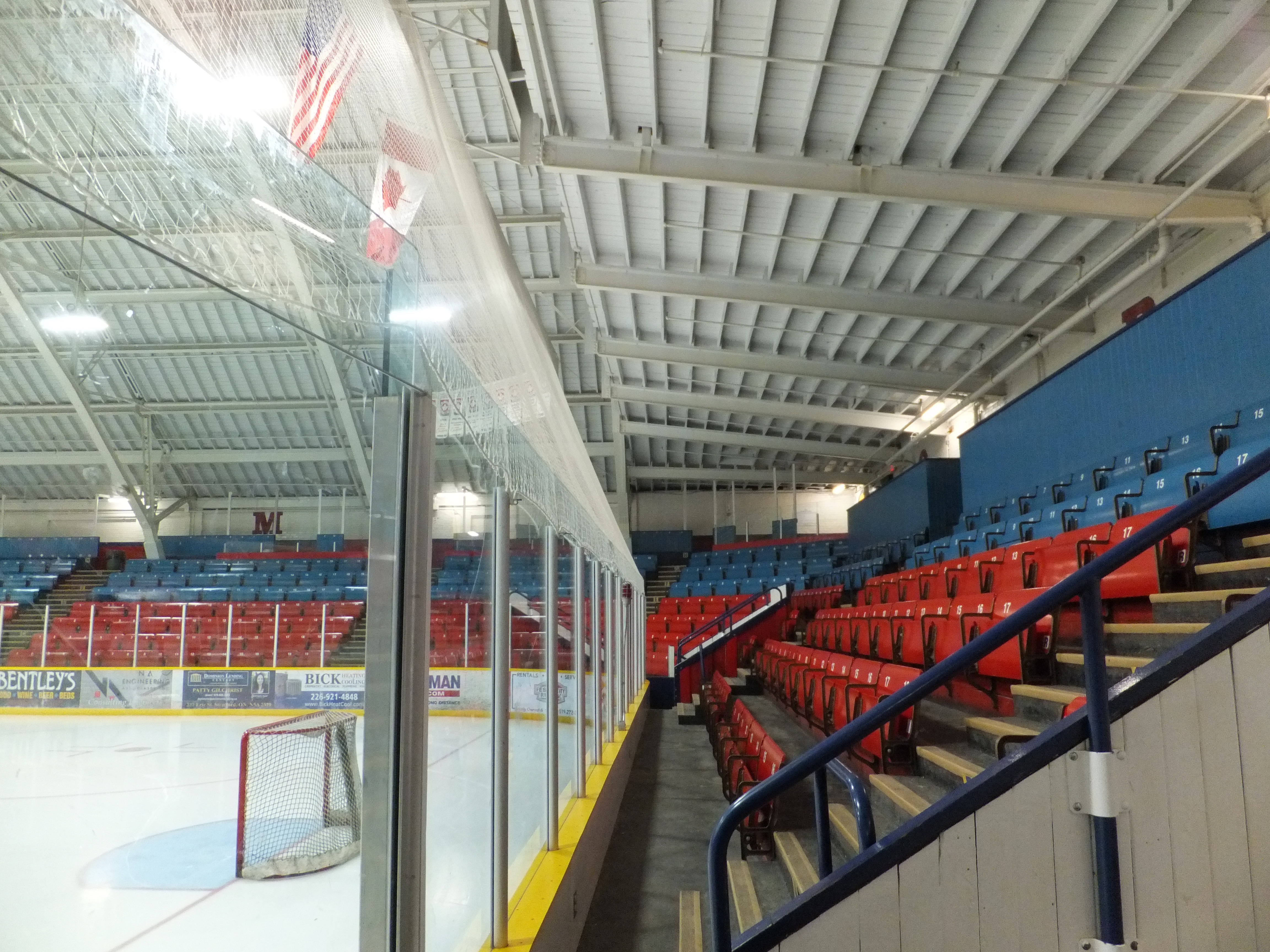Arena stadium seating overseeing ice skating rink with a hockey net