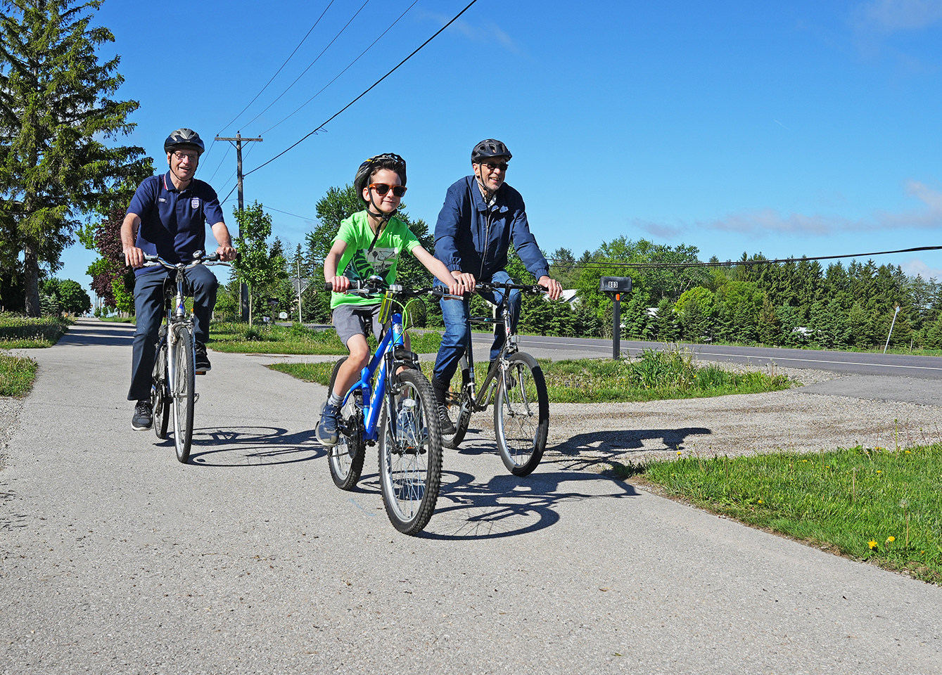 Three cyclists riding on asphalt pathway