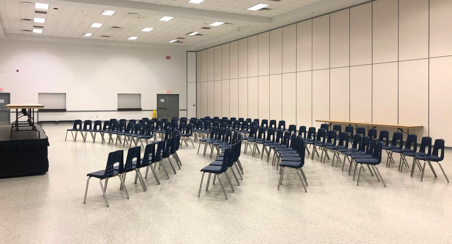 A banquet hall with chairs in rows.