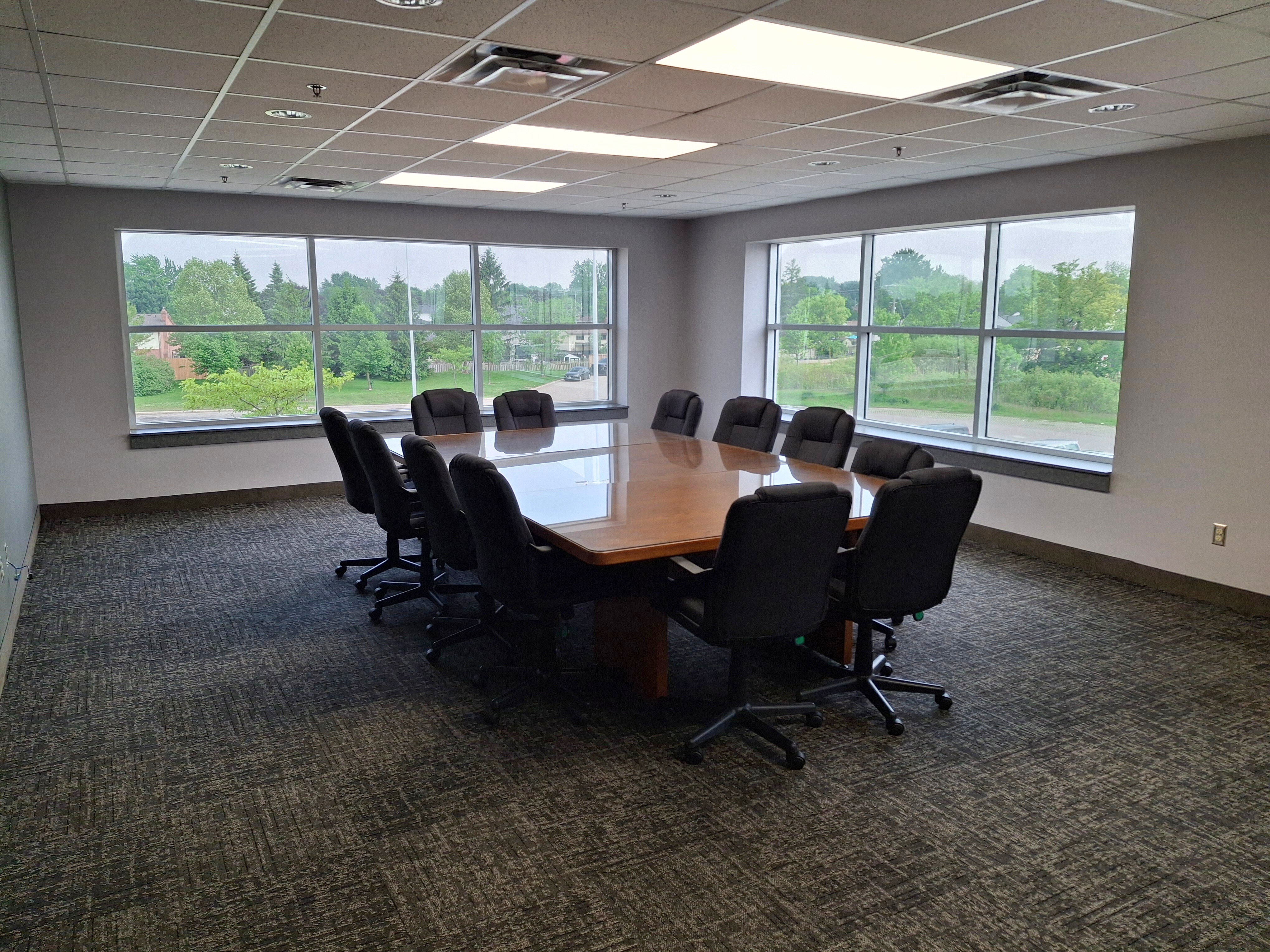 A boardroom with a table and chairs.