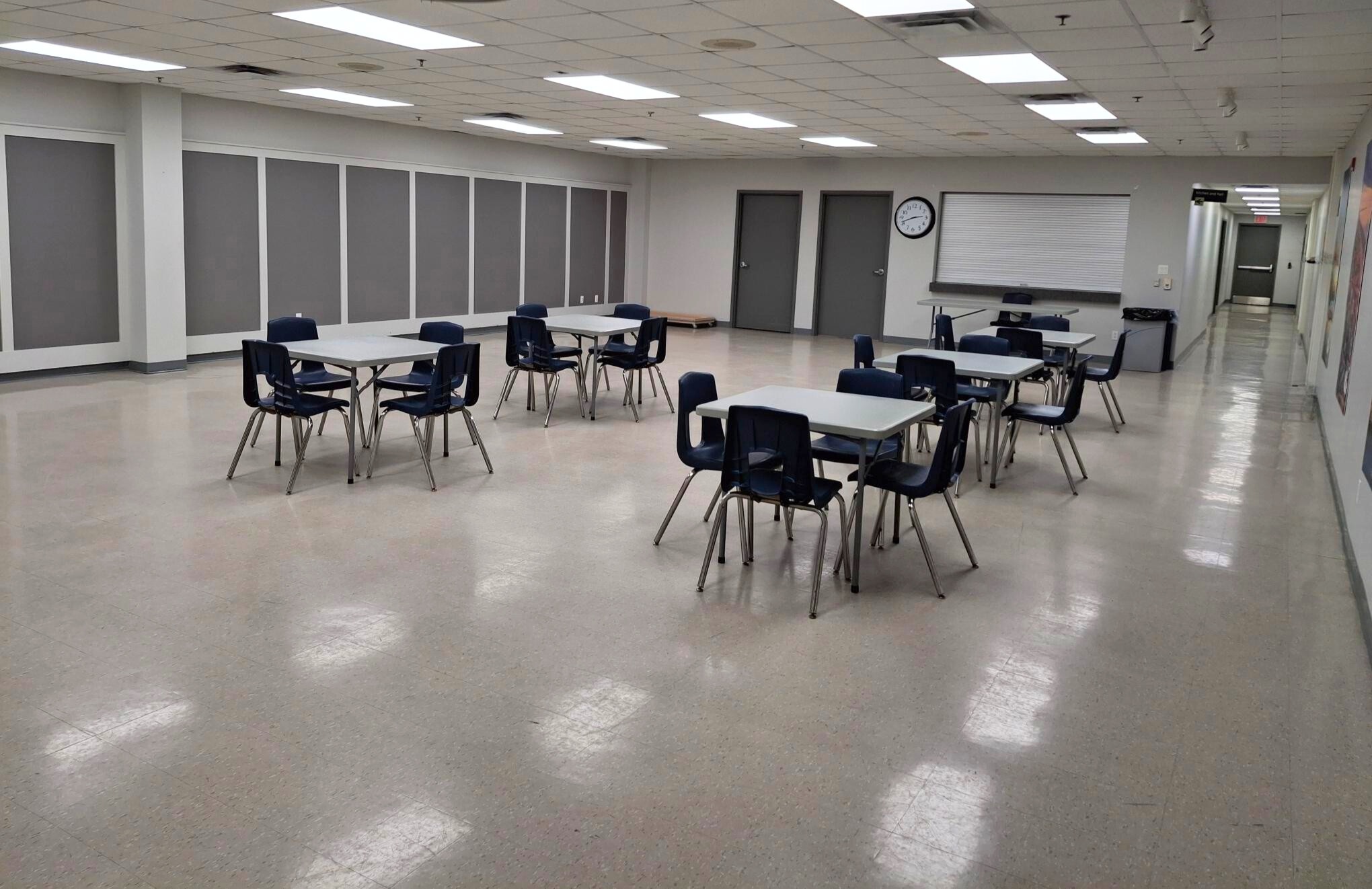A meeting room with tables and chairs.