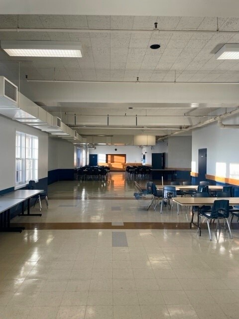 A large hall with tables and chairs set up.