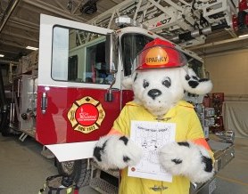 Sparky the Fire Dog standing in front of a fire truck