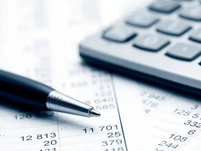 Closeup of a pen and calculator on a page of numbers