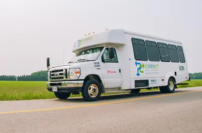 White bus driving along a rural road