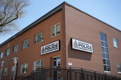 A brick building with signs on the corner that read Stratford Police Headquarters