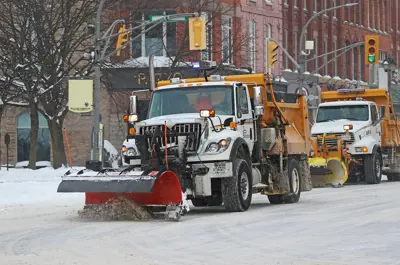 snowplow on a downtown street plowing snow