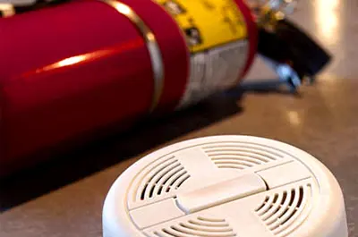Fire extinguisher and smoke alarm on a table