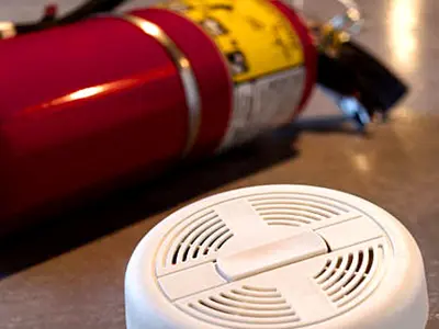 Fire extinguisher and smoke alarm on a table