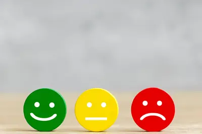 A green smiling face, a yellow neutral expression and a red frowning face.