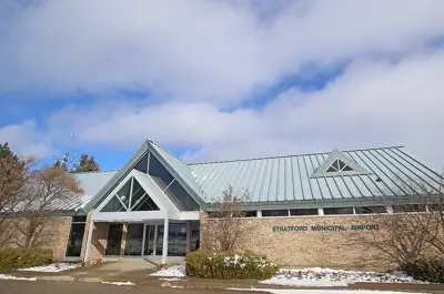 A brick building with metal roof. Stratford Municipal Airport lettering on the front. 