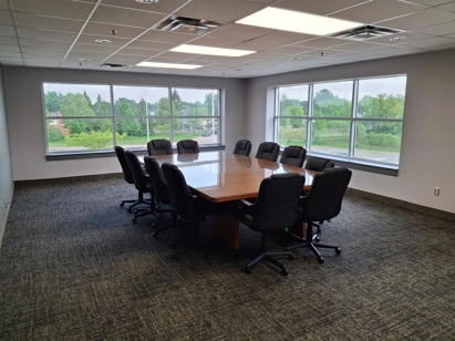 A boardroom with a table and chairs.